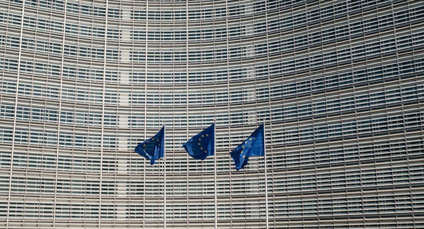 Illustrative European Union flags outside an EU building