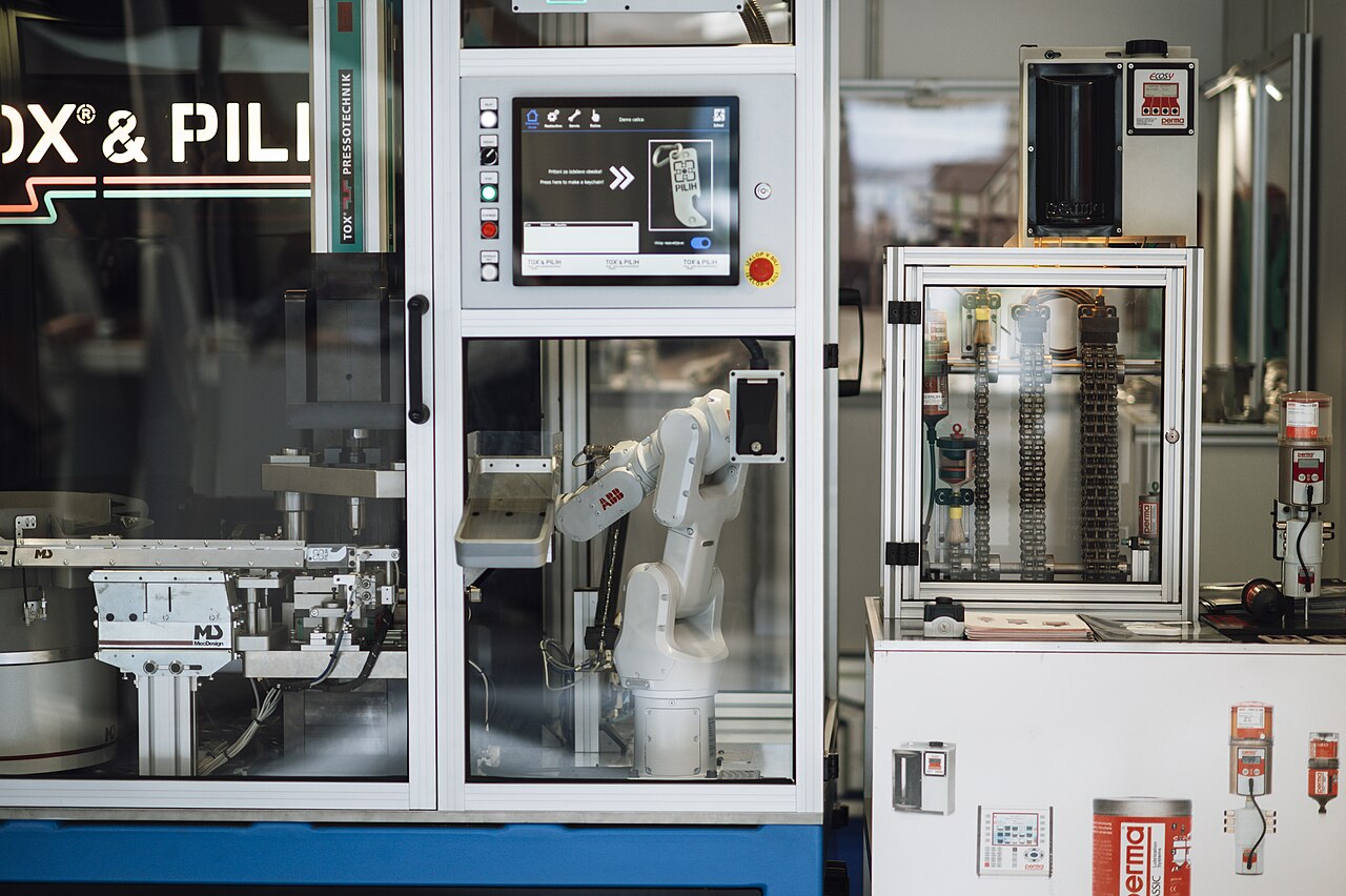 A robotic arm operating machinery in an automated factory workspace